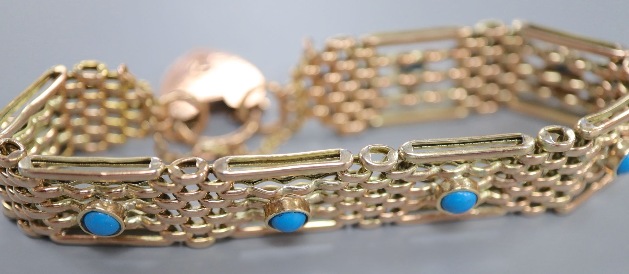 An early 20th century 9ct and seven stone turquoise set gatelink bracelet, approx. 18cm, gross 18.8 grams.